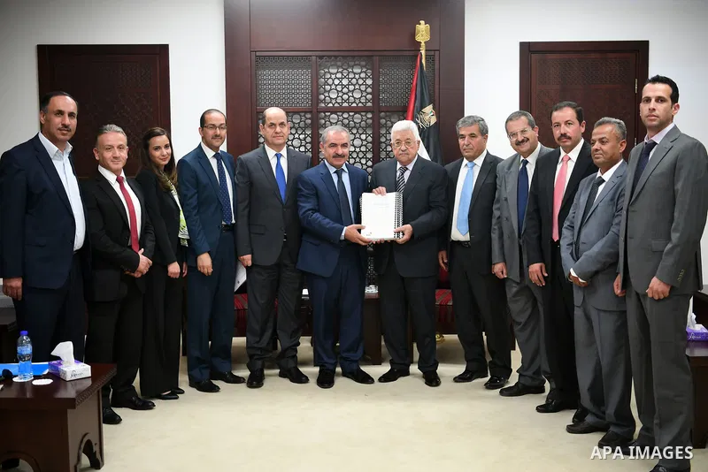 Palestinian President Mahmoud Abbas receipts the annual report of Pecdar at his headquarter in the West Bank city of Ramallah, on August 6, 2017. Photo by Osama Falah
