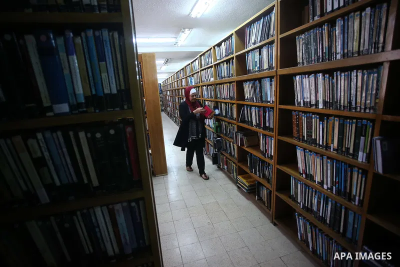 A Palestinian researcher selects a book at Nablus public library in the West Bank city of Nablus, on August 6, 2017. Nablus public library, the largest, and the oldest, in all of Palestine, opened in 1960, and library in...