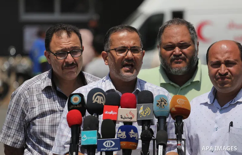 Palestinian doctors hold placards during a protest against a power cut and the Israeli blockade of the Gaza Strip, at al-Shifa Hospital in Gaza city on August 8, 2017. Photo by Mohammed Asad
