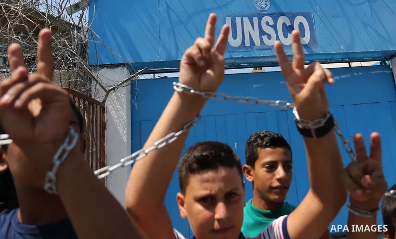 Palestinians hold posters of Mohammad El Halabi, World Vision's manager of operations in Gaza who was accused by Israel of funnelling millions of dollars in aid money to Hamas, during a protest in solidarity with El Hala...