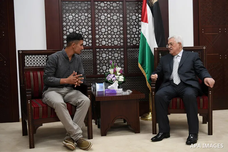 Palestinian President Mahmoud Abbas meets with Firas Bassam Abu Awwad, 17, who was lost his family in a traffic accident with an Israeli military vehicle in 2010, at his headquarter in the West Bank city of Ramallah on A...