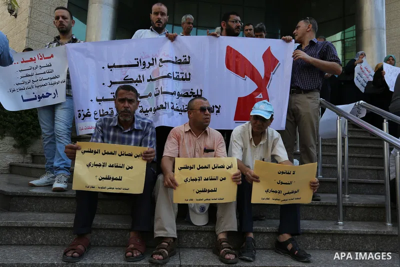 Palestinians, employed by the Palestinian Authority take part in a protest demanding their salaries in Gaza city on August 9, 2017. Photo by Ashraf Amra