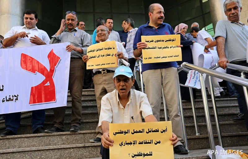 Palestinians, employed by the Palestinian Authority take part in a protest demanding their salaries in Gaza city on August 9, 2017. Photo by Ashraf Amra