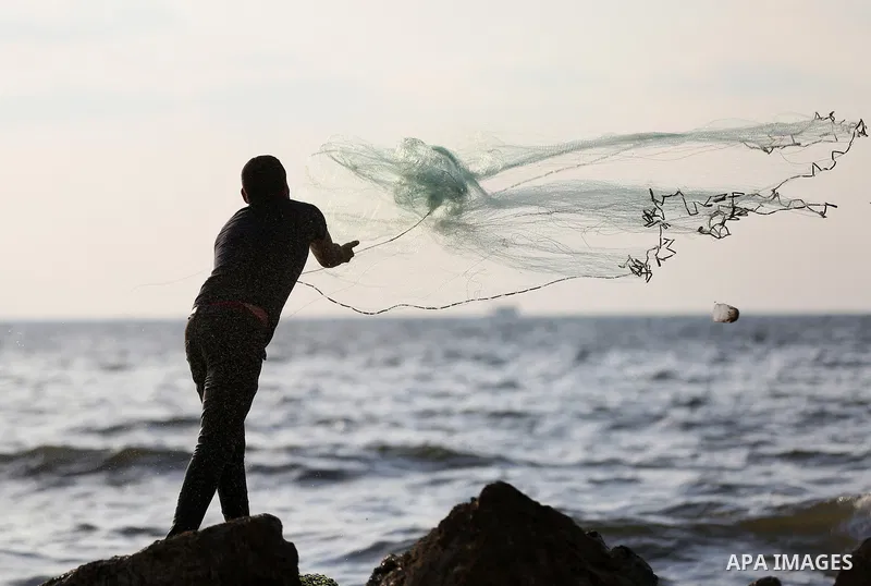 A Palestinian fisherman throws his net into the Mediterranean sea at the beach of Gaza city on August 9, 2017. Photo by Yasser Qudih