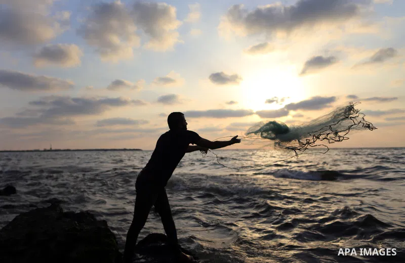 A Palestinian fisherman throws his net into the Mediterranean sea at the beach of Gaza city on August 9, 2017. Photo by Yasser Qudih