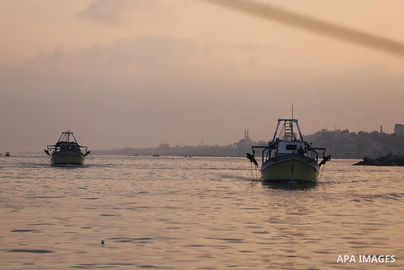 Palestinian fishermen ride a fishing boat, in Gaza seaport, on August 10, 2017. Photo by Mohammed Asad