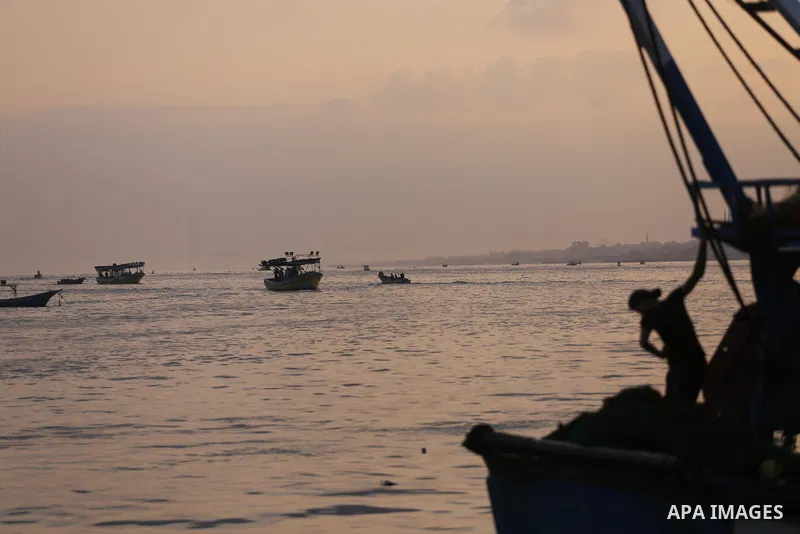 Palestinian fishermen ride a fishing boat, in Gaza seaport, on August 10, 2017. Photo by Mohammed Asad