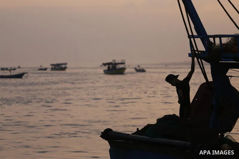 Palestinian fishermen ride a fishing boat, in Gaza seaport, on August 10, 2017. Photo by Mohammed Asad