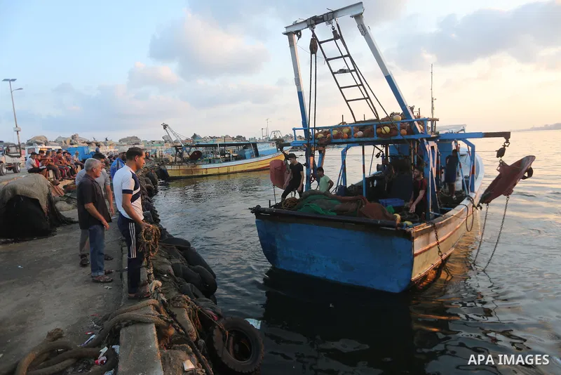 Palestinian fishermen ride a fishing boat, in Gaza seaport, on August 10, 2017. Photo by Mohammed Asad