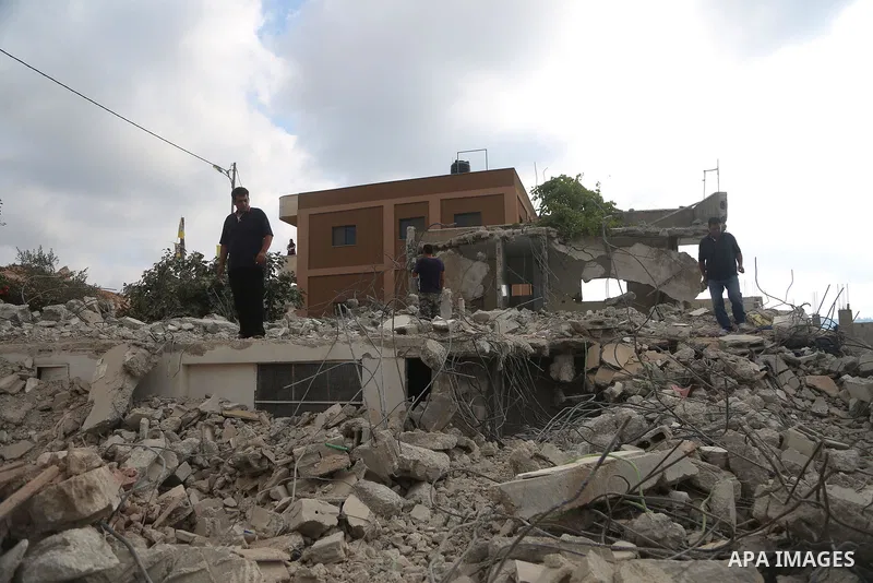People walk through the rubble of the house of a Palestinian assailant after it was demolished by Israeli troops in the West Bank village of Deir Abu Mashal, near Ramallah August 10, 2017. Photo by Shadi Hatem