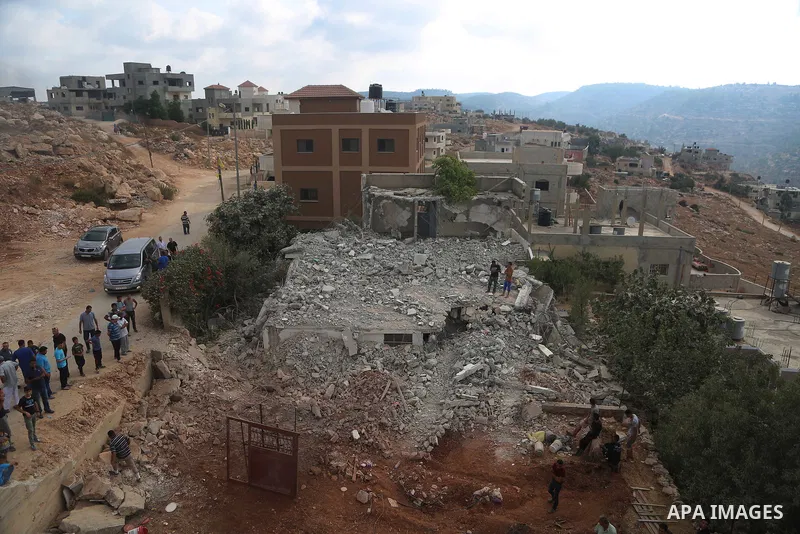 People walk through the rubble of the house of a Palestinian assailant after it was demolished by Israeli troops in the West Bank village of Deir Abu Mashal, near Ramallah August 10, 2017. Photo by Shadi Hatem