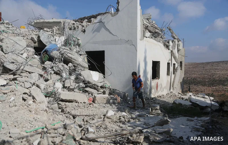 People gather around the remains of the house of a Palestinian assailant after it was demolished by Israeli troops in the West Bank village of Deir Abu Mashal, near Ramallah August 10, 2017. Photo by Shadi Hatem