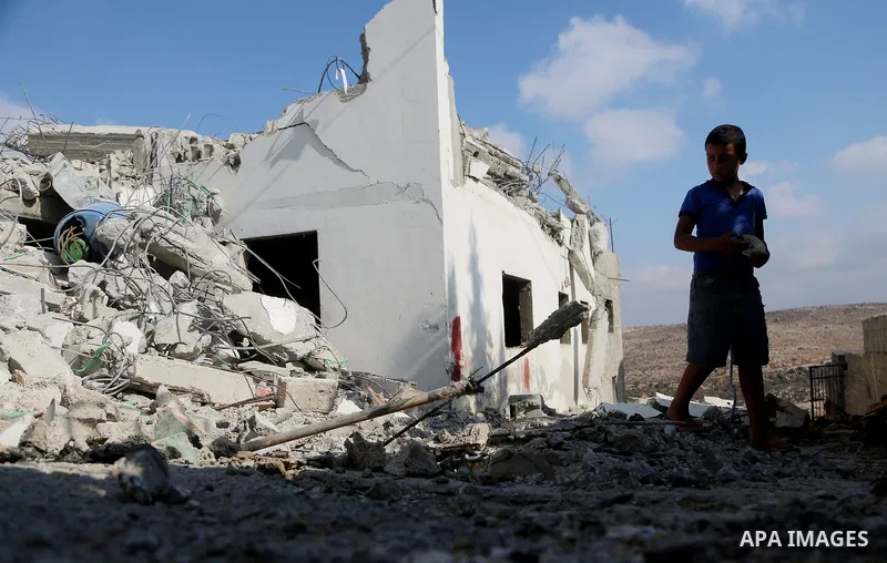 People gather around the remains of the house of a Palestinian assailant after it was demolished by Israeli troops in the West Bank village of Deir Abu Mashal, near Ramallah August 10, 2017. Photo by Shadi Hatem