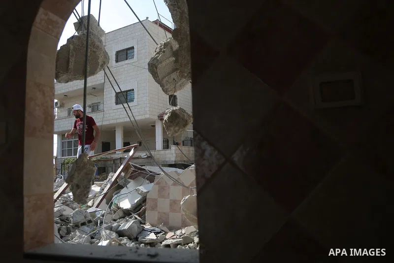 People gather around the remains of the house of a Palestinian assailant after it was demolished by Israeli troops in the West Bank village of Deir Abu Mashal, near Ramallah August 10, 2017. Photo by Shadi Hatem