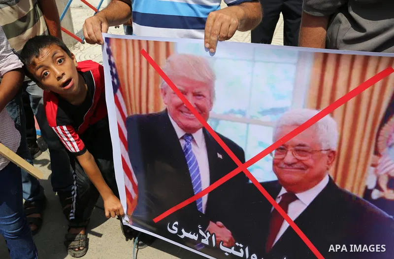 Palestinians hold a poster depicting Palestinian President Mahmoud Abbas during a protest against the blockade on Gaza strip and demanding their salaries in Gaza City on August 10, 2017. Photo by Ashraf Amra