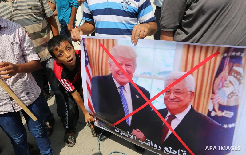 Palestinians hold a poster depicting Palestinian President Mahmoud Abbas during a protest against the blockade on Gaza strip and demanding their salaries in Gaza City on August 10, 2017. Photo by Ashraf Amra