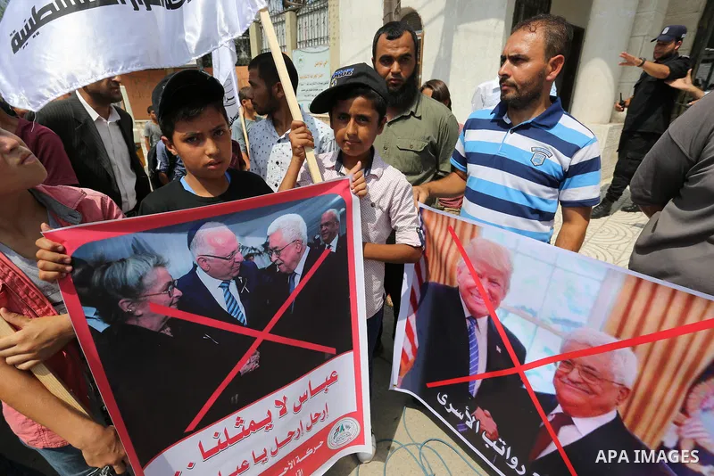 Palestinians hold a poster depicting Palestinian President Mahmoud Abbas during a protest against the blockade on Gaza strip and demanding their salaries in Gaza City on August 10, 2017. Photo by Ashraf Amra