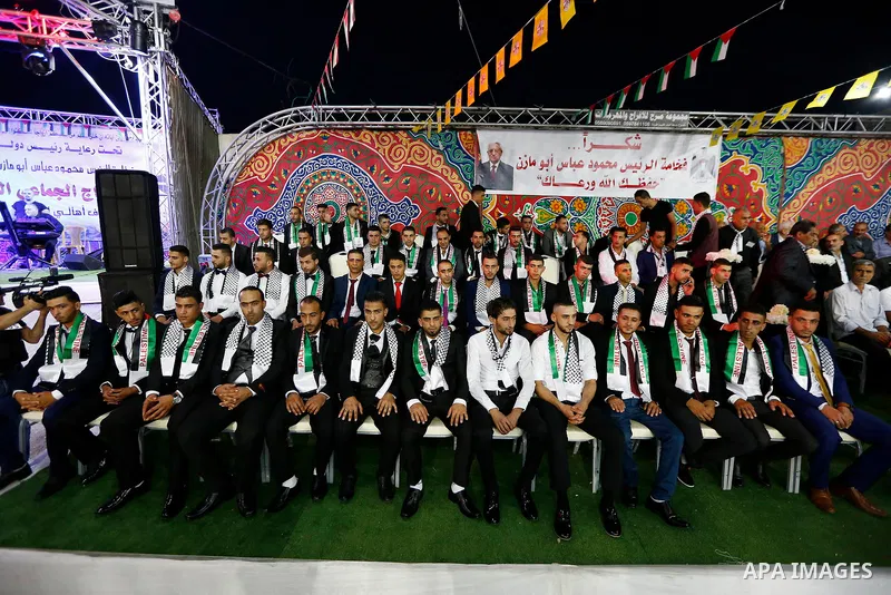 Thirty nine Palestinian grooms take part in a mass wedding funded by Palestinian President Mahmoud Abbas in the West Bank village of Tafouh, east of Hebron, on August 10, 2017. Photo by Wisam Hashlamoun