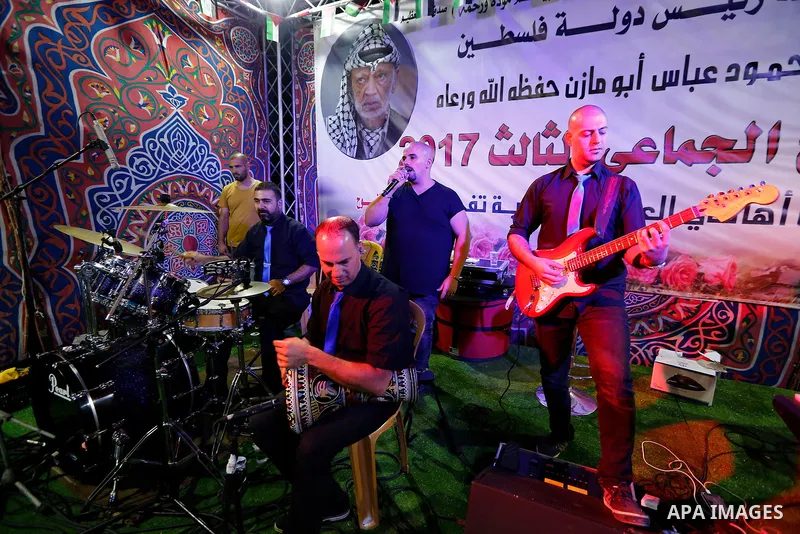 A musical band perform during a mass wedding for Thirty nine Palestinian grooms funded by Palestinian President Mahmoud Abbas in the West Bank village of Tafouh, east of Hebron, on August 10, 2017. Photo by Wisam Hashlam...