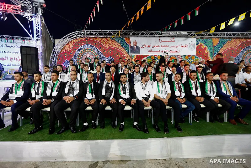Thirty nine Palestinian grooms take part in a mass wedding funded by Palestinian President Mahmoud Abbas in the West Bank village of Tafouh, east of Hebron, on August 10, 2017. Photo by Wisam Hashlamoun