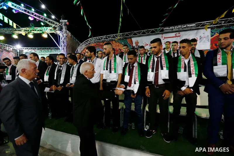 Thirty nine Palestinian grooms take part in a mass wedding funded by Palestinian President Mahmoud Abbas in the West Bank village of Tafouh, east of Hebron, on August 10, 2017. Photo by Wisam Hashlamoun