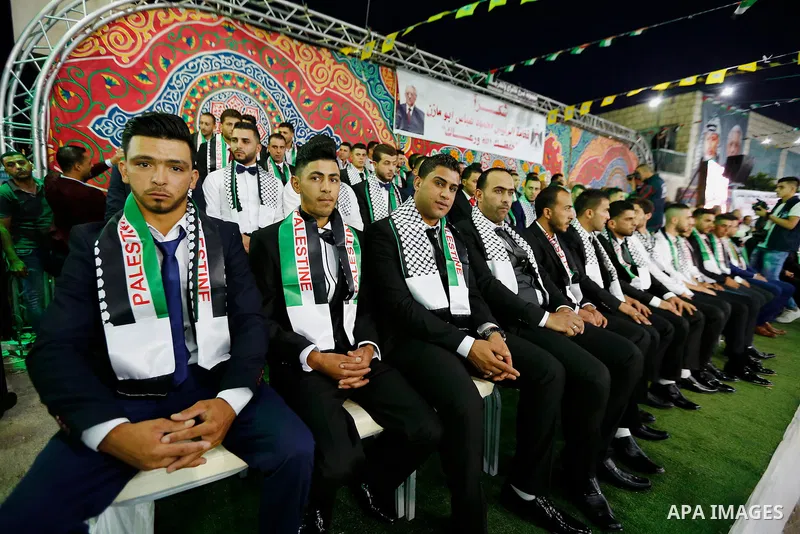 Thirty nine Palestinian grooms take part in a mass wedding funded by Palestinian President Mahmoud Abbas in the West Bank village of Tafouh, east of Hebron, on August 10, 2017. Photo by Wisam Hashlamoun