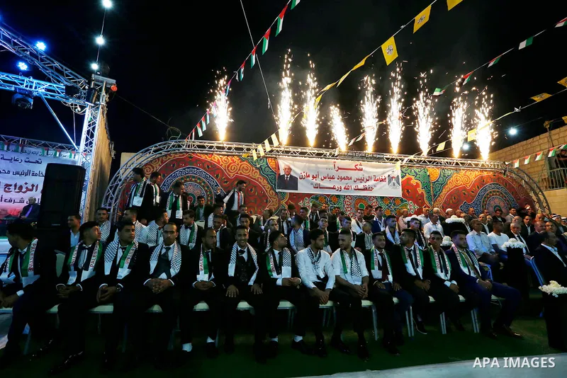 Thirty nine Palestinian grooms take part in a mass wedding funded by Palestinian President Mahmoud Abbas in the West Bank village of Tafouh, east of Hebron, on August 10, 2017. Photo by Wisam Hashlamoun