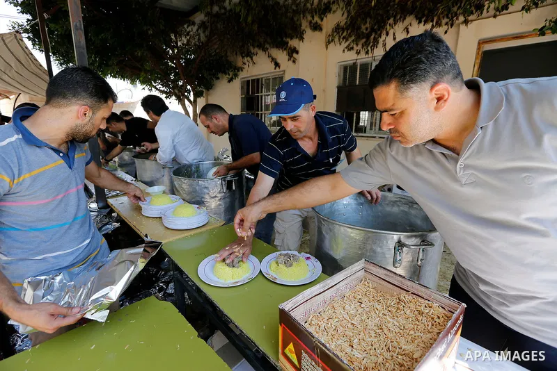 Palestinians prepare Lunch food during a mass wedding for Thirty nine Palestinian grooms funded by Palestinian President Mahmoud Abbas in the West Bank village of Tafouh, east of Hebron, on August 11, 2017. Photo by Wisa...