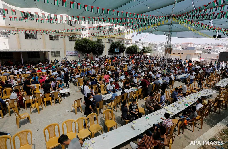 Palestinians prepare Lunch food during a mass wedding for Thirty nine Palestinian grooms funded by Palestinian President Mahmoud Abbas in the West Bank village of Tafouh, east of Hebron, on August 11, 2017. Photo by Wisa...