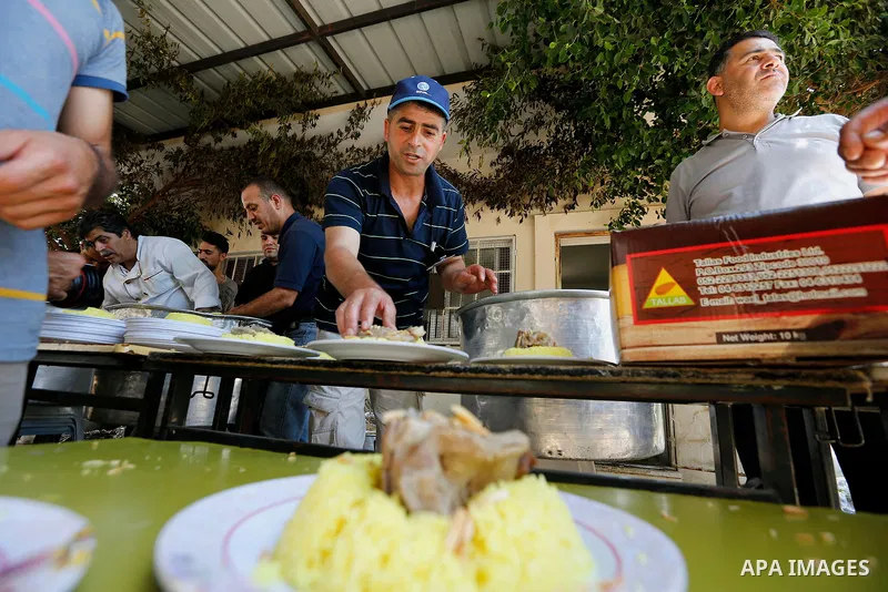 Palestinians prepare Lunch food during a mass wedding for Thirty nine Palestinian grooms funded by Palestinian President Mahmoud Abbas in the West Bank village of Tafouh, east of Hebron, on August 11, 2017. Photo by Wisa...