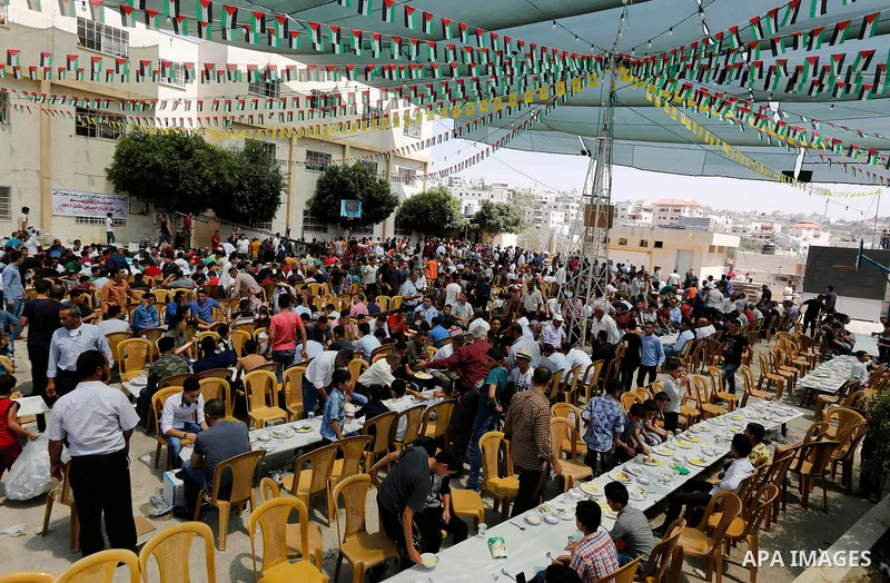 Palestinians prepare Lunch food during a mass wedding for Thirty nine Palestinian grooms funded by Palestinian President Mahmoud Abbas in the West Bank village of Tafouh, east of Hebron, on August 11, 2017. Photo by Wisa...