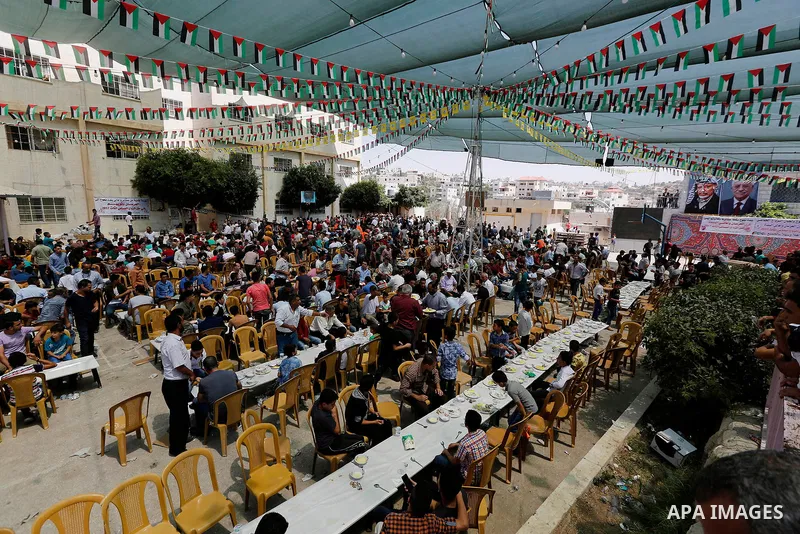 Palestinians prepare Lunch food during a mass wedding for Thirty nine Palestinian grooms funded by Palestinian President Mahmoud Abbas in the West Bank village of Tafouh, east of Hebron, on August 11, 2017. Photo by Wisa...