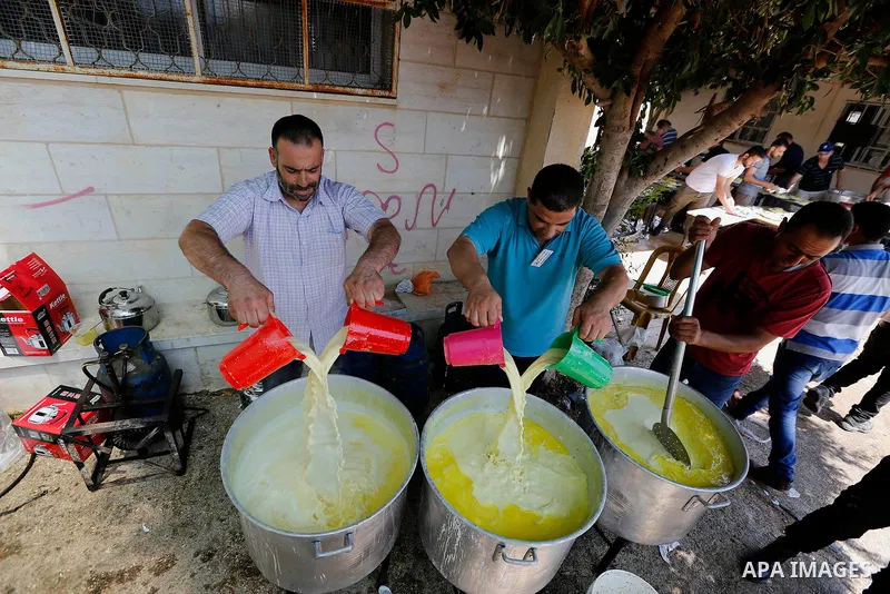 Palestinians prepare Lunch food during a mass wedding for Thirty nine Palestinian grooms funded by Palestinian President Mahmoud Abbas in the West Bank village of Tafouh, east of Hebron, on August 11, 2017. Photo by Wisa...
