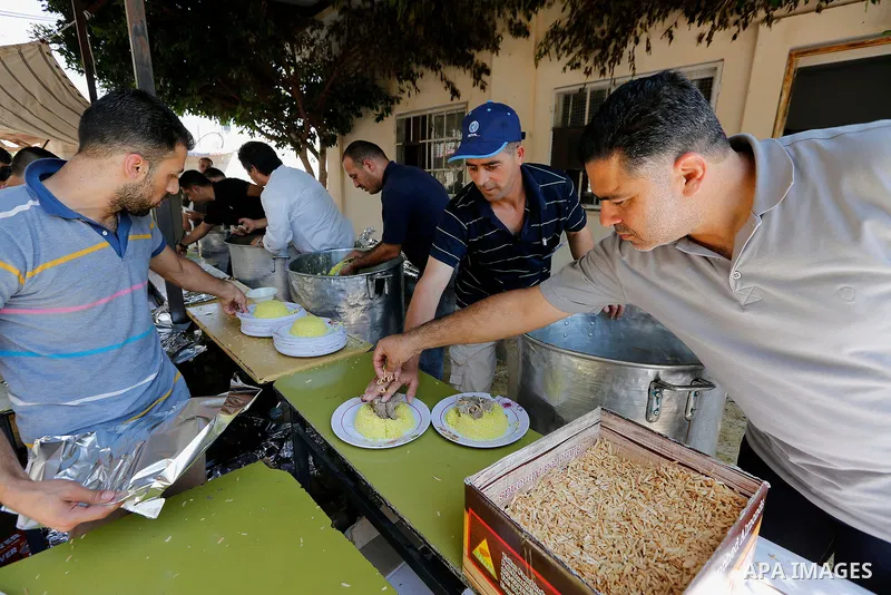 Palestinians prepare Lunch food during a mass wedding for Thirty nine Palestinian grooms funded by Palestinian President Mahmoud Abbas in the West Bank village of Tafouh, east of Hebron, on August 11, 2017. Photo by Wisa...
