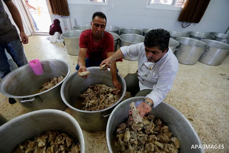 Palestinians prepare Lunch food during a mass wedding for Thirty nine Palestinian grooms funded by Palestinian President Mahmoud Abbas in the West Bank village of Tafouh, east of Hebron, on August 11, 2017. Photo by Wisa...