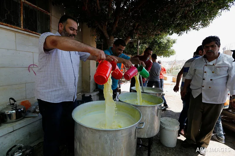 Palestinians prepare Lunch food during a mass wedding for Thirty nine Palestinian grooms funded by Palestinian President Mahmoud Abbas in the West Bank village of Tafouh, east of Hebron, on August 11, 2017. Photo by Wisa...