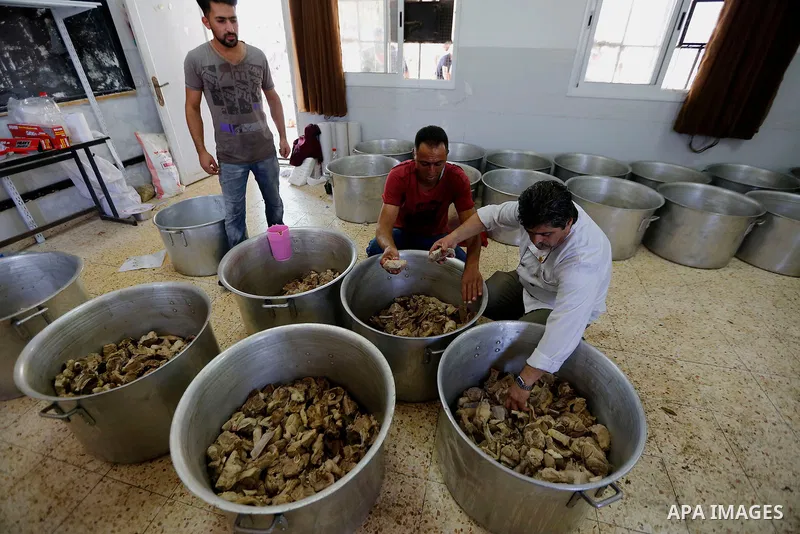 Palestinians prepare Lunch food during a mass wedding for Thirty nine Palestinian grooms funded by Palestinian President Mahmoud Abbas in the West Bank village of Tafouh, east of Hebron, on August 11, 2017. Photo by Wisa...