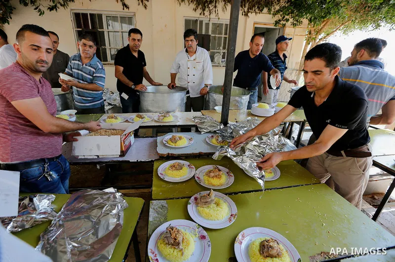 Palestinians prepare Lunch food during a mass wedding for Thirty nine Palestinian grooms funded by Palestinian President Mahmoud Abbas in the West Bank village of Tafouh, east of Hebron, on August 11, 2017. Photo by Wisa...