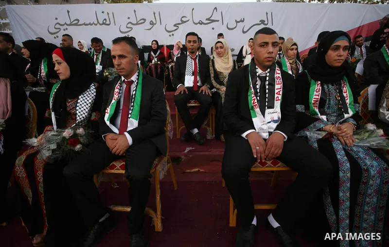 Palestinian 65 couples take part in a mass wedding ceremony funded by Palestinian President Mahmoud Abbas at Al-Fara refugee camp near the West Bank city of Nablus, on August 10, 2017. Photo by Ayman Ameen