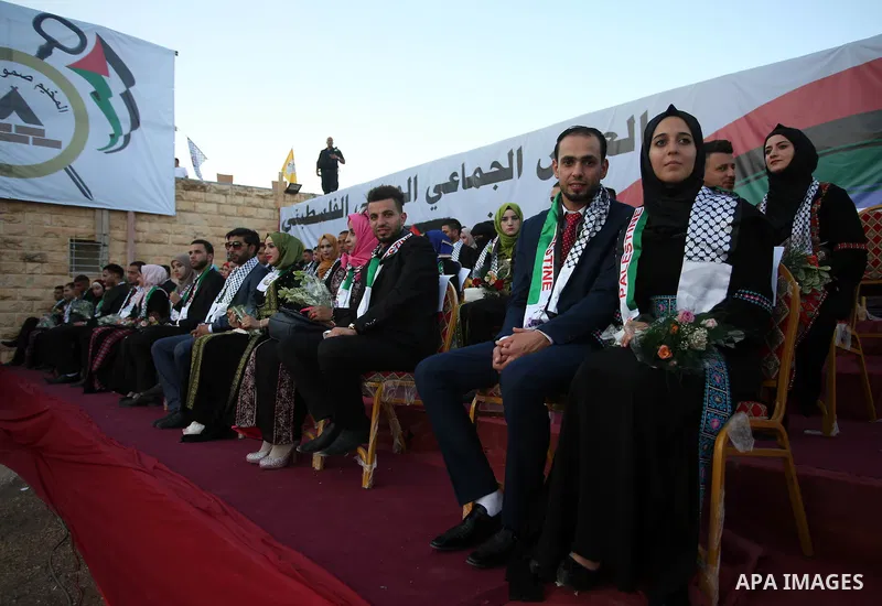 Palestinian 65 couples take part in a mass wedding ceremony funded by Palestinian President Mahmoud Abbas at Al-Fara refugee camp near the West Bank city of Nablus, on August 10, 2017. Photo by Ayman Ameen