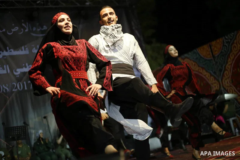 Members of Palestinian dance Dabka band perform during a mass wedding ceremony for 65 couples funded by Palestinian President Mahmoud Abbas at Al-Fara refugee camp near the West Bank city of Nablus, on August 10, 2017. P...