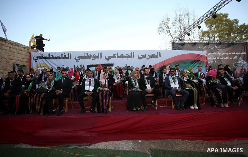 Palestinian 65 couples take part in a mass wedding ceremony funded by Palestinian President Mahmoud Abbas at Al-Fara refugee camp near the West Bank city of Nablus, on August 10, 2017. Photo by Ayman Ameen