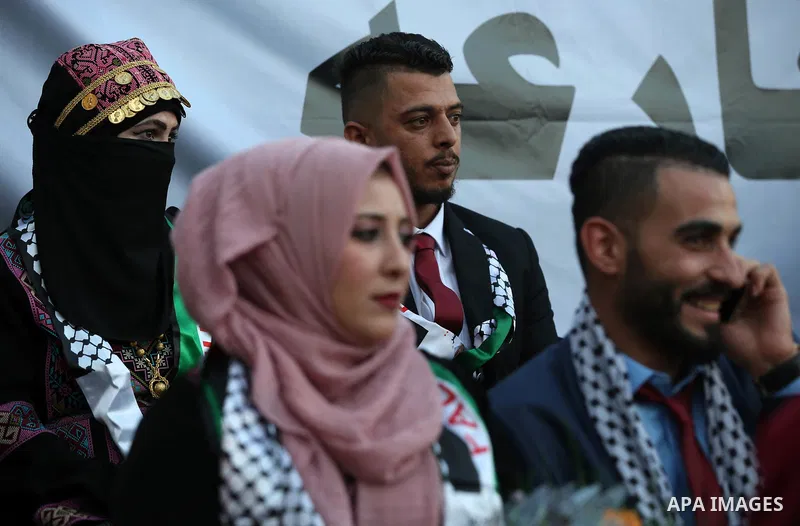 Palestinian 65 couples take part in a mass wedding ceremony funded by Palestinian President Mahmoud Abbas at Al-Fara refugee camp near the West Bank city of Nablus, on August 10, 2017. Photo by Ayman Ameen