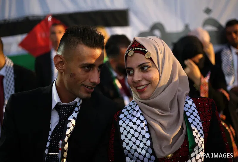 Palestinian 65 couples take part in a mass wedding ceremony funded by Palestinian President Mahmoud Abbas at Al-Fara refugee camp near the West Bank city of Nablus, on August 10, 2017. Photo by Ayman Ameen