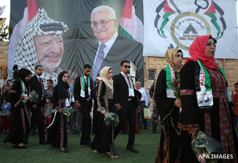 Palestinian 65 couples take part in a mass wedding ceremony funded by Palestinian President Mahmoud Abbas at Al-Fara refugee camp near the West Bank city of Nablus, on August 10, 2017. Photo by Ayman Ameen
