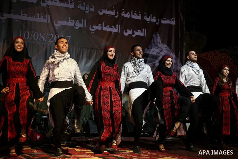 Members of Palestinian dance Dabka band perform during a mass wedding ceremony for 65 couples funded by Palestinian President Mahmoud Abbas at Al-Fara refugee camp near the West Bank city of Nablus, on August 10, 2017. P...