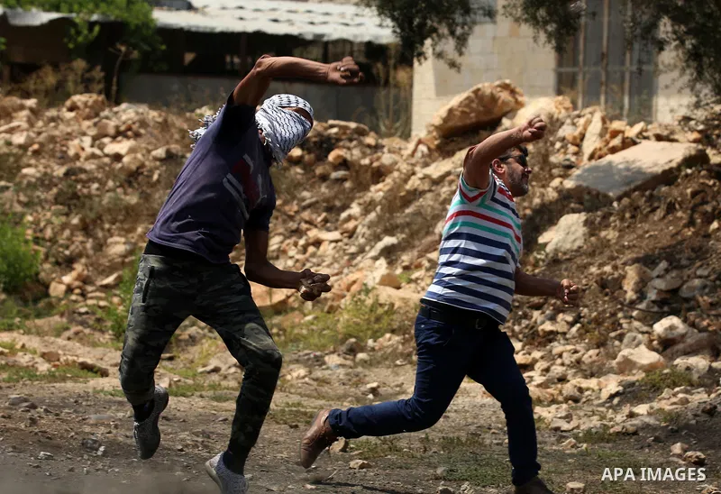 Palestinian protesters hurl stones towards Israeli security forces during clashes following a demonstration against the expropriation of Palestinian land by Israel in the village of Kfar Qaddum, near Nablus in the occupi...