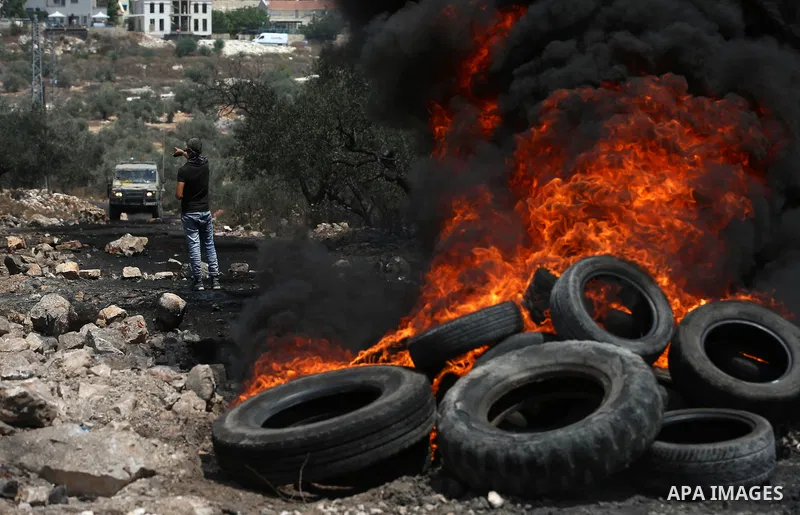 A Palestinian protester hurls stones towards Israeli security forces during clashes following a demonstration against the expropriation of Palestinian land by Israel in the village of Kfar Qaddum, near Nablus in the occu...