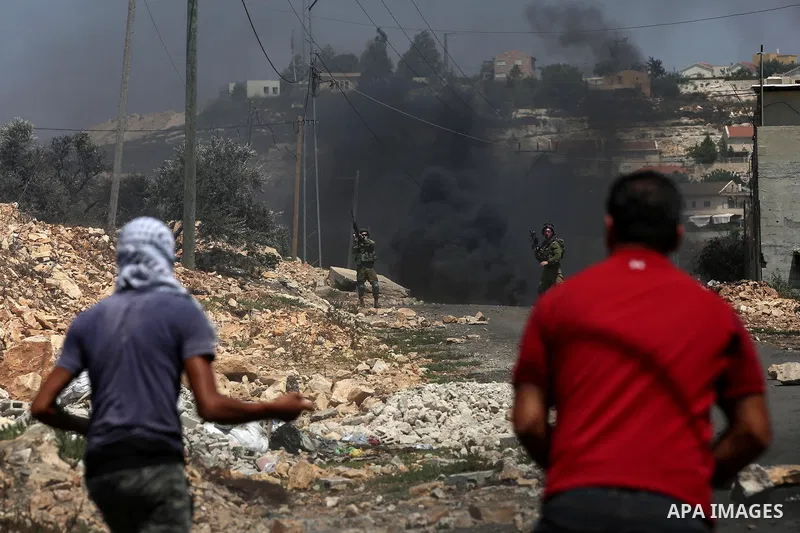 Palestinian protesters hurl stones towards Israeli security forces during clashes following a demonstration against the expropriation of Palestinian land by Israel in the village of Kfar Qaddum, near Nablus in the occupi...