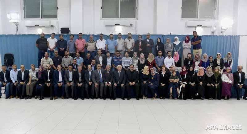 Palestinian President Mahmoud Abbas meets with Palestinian teachers who will be send to Kuwait, in the West Bank city of Ramallah, on August 12, 2017. Photo by Osama Falah